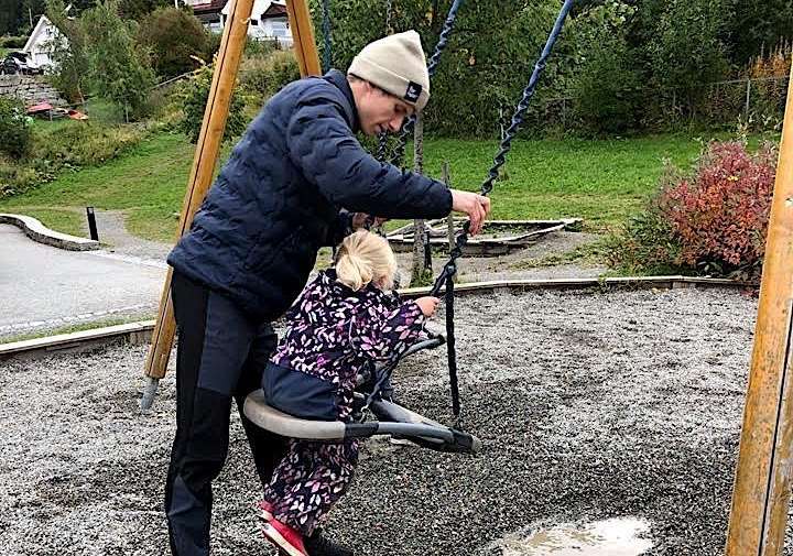 Halvor Egner Granerud hjelper en liten jente med lyst hår og regndress å huske